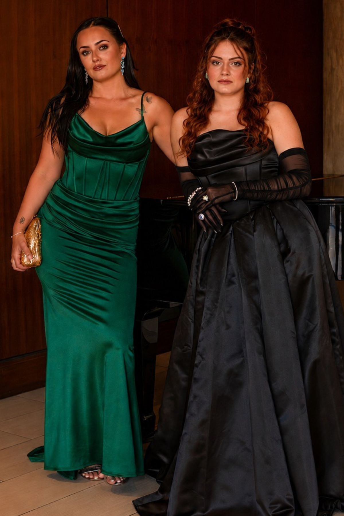 Two women in green and black satin gowns